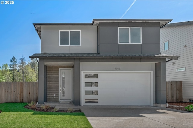 view of front of home with fence, driveway, and a garage