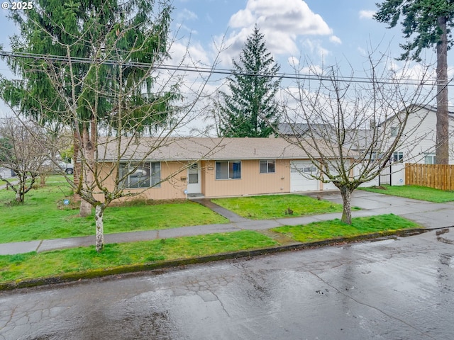 single story home with a garage, fence, aphalt driveway, and a front yard