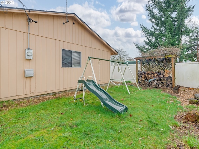 view of jungle gym featuring a yard and fence