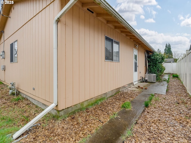 view of side of home featuring a fenced backyard and central AC unit