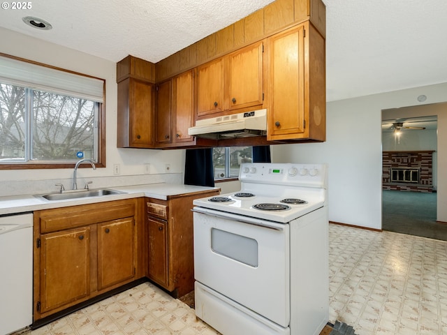 kitchen with light floors, white appliances, a sink, and under cabinet range hood