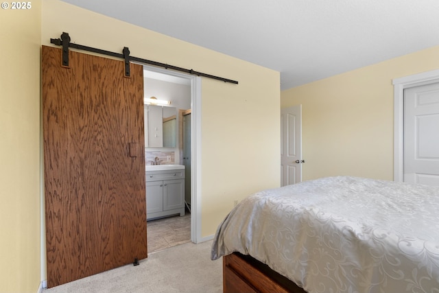 611 Summit Ridge Dr, The Dalles, OR 97058 - bedroom featuring light colored carpet, a barn door, ensuite bath, and baseboards