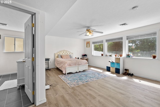 611 Summit Ridge Dr, The Dalles, OR 97058 - bedroom featuring a textured ceiling, baseboards, wood finished floors, and a ceiling fan