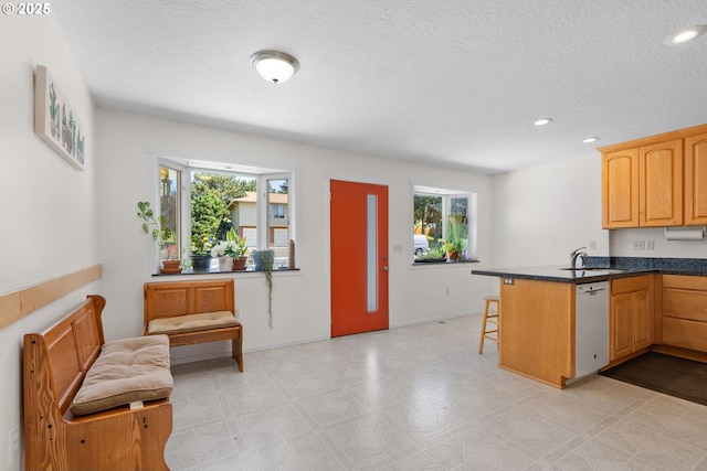 611 Summit Ridge Dr, The Dalles, OR 97058 - kitchen featuring white dishwasher, a kitchen breakfast bar, healthy amount of natural light, a peninsula, and a textured ceiling