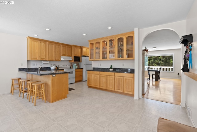 611 Summit Ridge Dr, The Dalles, OR 97058 - kitchen with white appliances, under cabinet range hood, a peninsula, a sink, and recessed lighting
