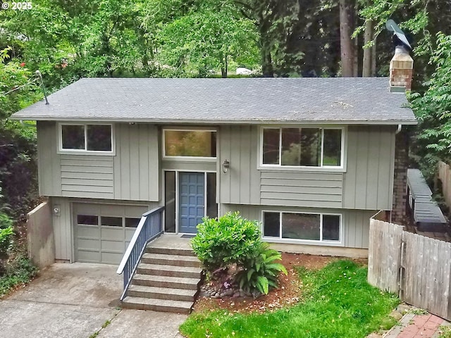 1745 NE W Devils Lake Rd, Lincoln City, OR 97367 - raised ranch featuring a chimney, a shingled roof, driveway, and an attached garage