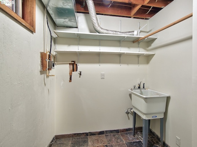 1745 NE W Devils Lake Rd, Lincoln City, OR 97367 - laundry area featuring baseboards and dark stone finish floors