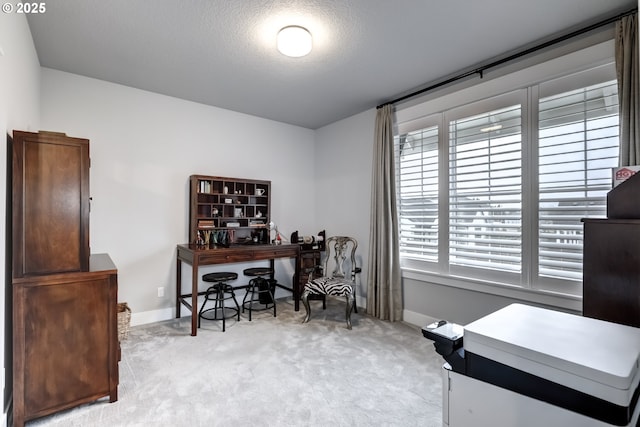 carpeted office space featuring a textured ceiling