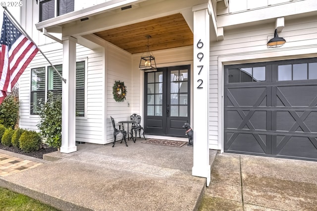 doorway to property with a garage and french doors