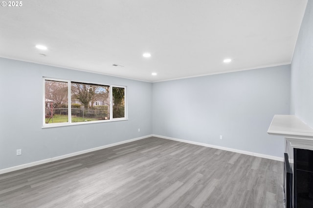 unfurnished living room featuring light wood-type flooring and ornamental molding