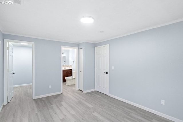 unfurnished bedroom featuring a closet, connected bathroom, crown molding, and light hardwood / wood-style flooring