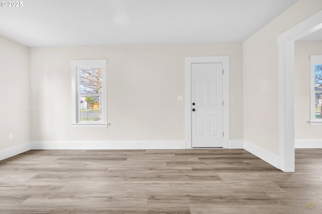 unfurnished room featuring baseboards and wood finished floors