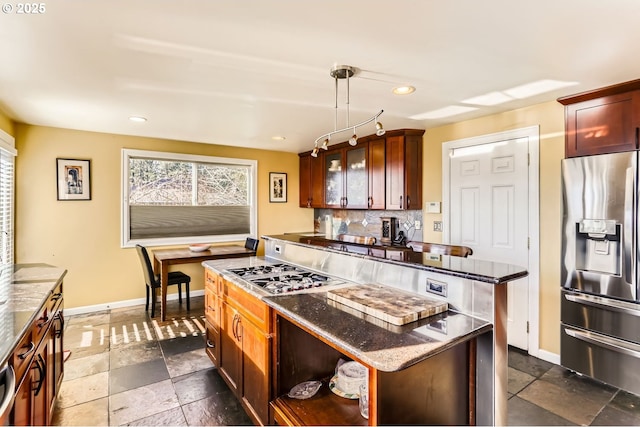 kitchen featuring decorative backsplash, pendant lighting, stainless steel appliances, and a kitchen island