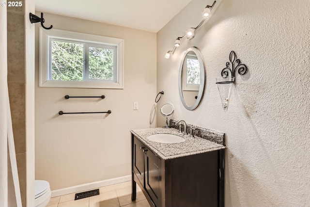 bathroom featuring toilet, tile patterned flooring, and vanity