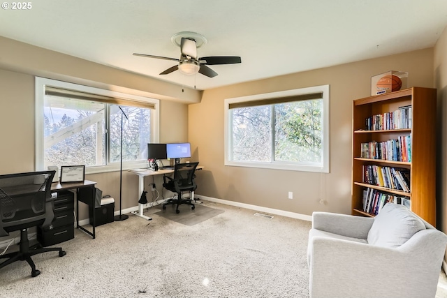 home office featuring light carpet and ceiling fan