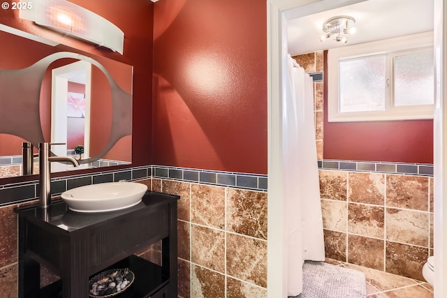 bathroom with vanity and tile walls