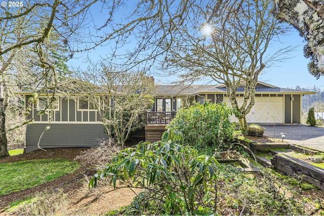 ranch-style home with a garage and a wooden deck