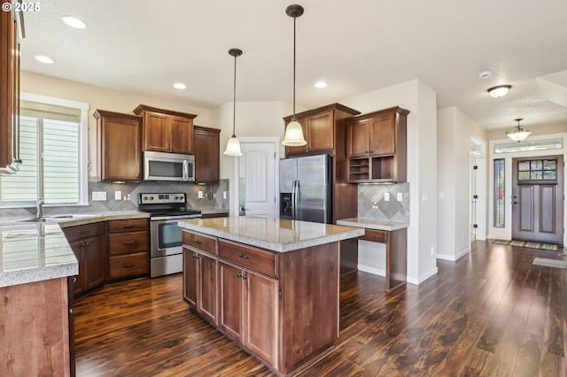 kitchen with stainless steel appliances, tasteful backsplash, a sink, and dark wood-type flooring