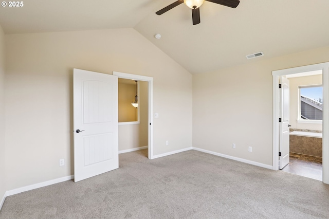 unfurnished bedroom featuring visible vents, vaulted ceiling, baseboards, connected bathroom, and carpet