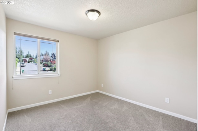 unfurnished room with carpet floors, a textured ceiling, and baseboards
