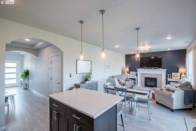 4507 Sagecrest Dr, Albany, OR 97322 - kitchen featuring a fireplace, arched walkways, light countertops, light wood finished floors, and recessed lighting