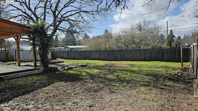 view of yard with a fenced backyard, a shed, and an outdoor structure