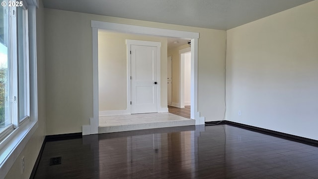 empty room with visible vents, baseboards, and wood finished floors