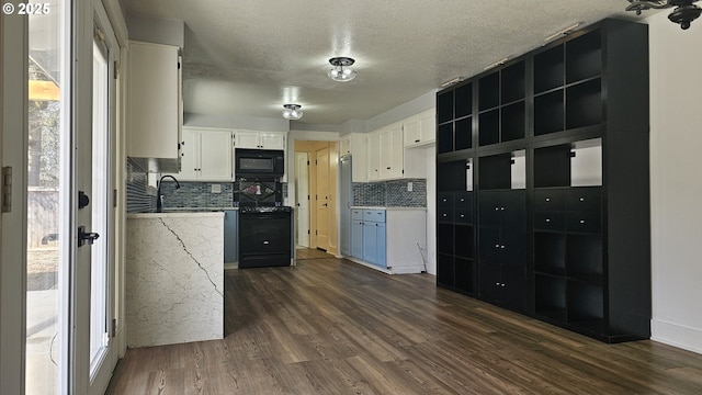 kitchen featuring dark wood-style floors, white cabinets, black appliances, and tasteful backsplash