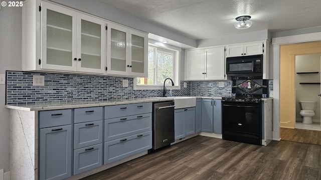 kitchen featuring white cabinets, dark wood-type flooring, a sink, black appliances, and backsplash