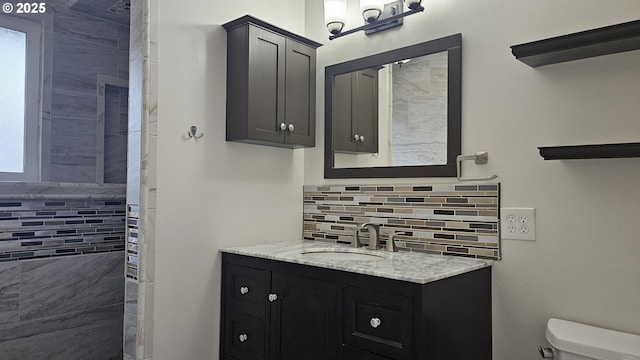 bathroom with vanity, toilet, and decorative backsplash