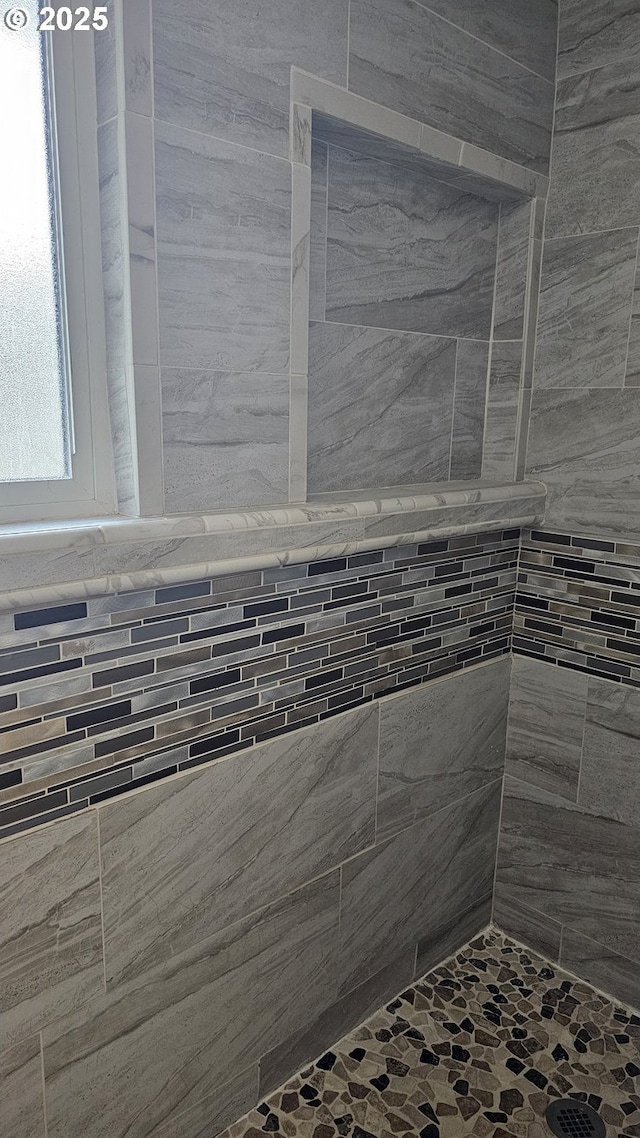 interior details featuring tiled shower