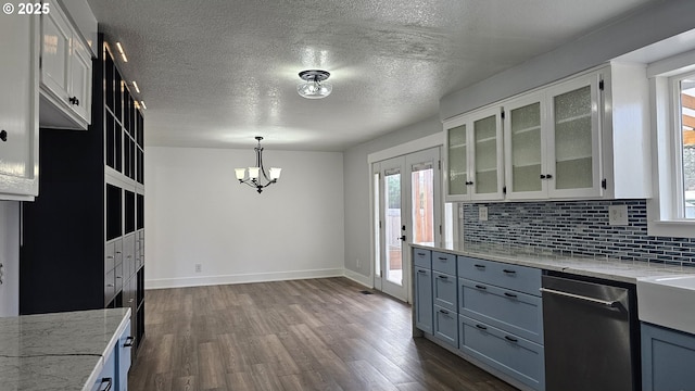 kitchen with dark wood-style floors, light stone counters, decorative backsplash, and stainless steel dishwasher