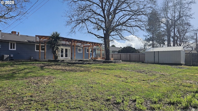 view of yard with french doors, fence, an outdoor structure, and a shed