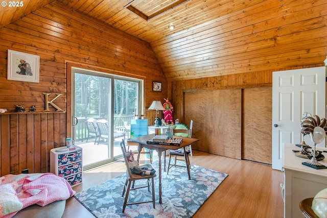 dining room featuring wooden ceiling, lofted ceiling, wood finished floors, and wood walls