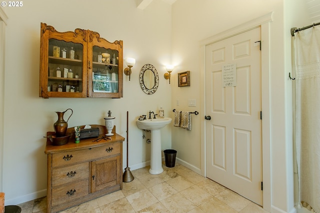 full bathroom featuring baseboards and a sink