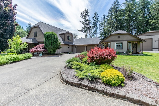 view of front facade with a front lawn, driveway, and a garage