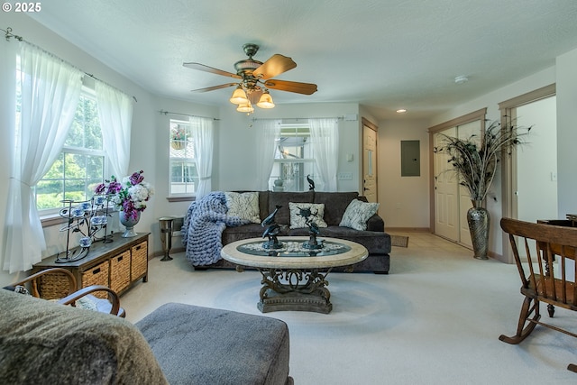 living area with electric panel, carpet, baseboards, and a ceiling fan