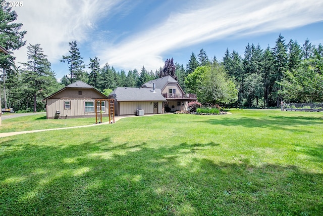 exterior space featuring central AC unit, a lawn, a wooden deck, and board and batten siding