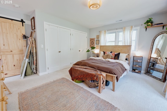 12545 SW Fairfield St, Beaverton, OR 97005 - carpeted bedroom with a barn door, two closets, and baseboards