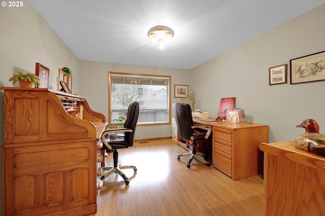 office space with light hardwood / wood-style floors and a textured ceiling