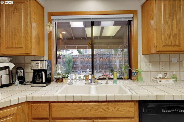 kitchen with decorative backsplash, sink, dishwasher, and tile countertops