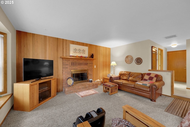 living room with carpet floors, a fireplace, and wooden walls