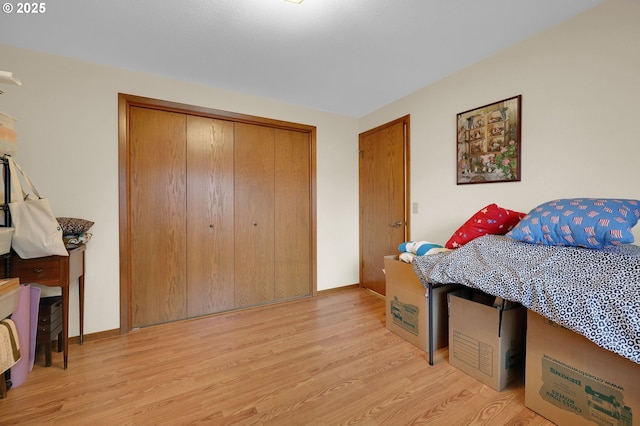 bedroom with light hardwood / wood-style floors and a closet