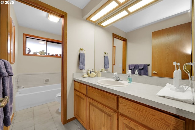 bathroom featuring a washtub, toilet, vanity, and tile patterned flooring