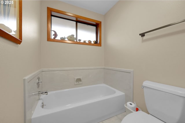 bathroom featuring toilet, a bathing tub, and tile patterned flooring