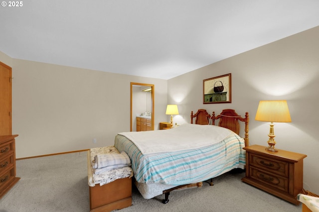 bedroom featuring ensuite bathroom and light carpet