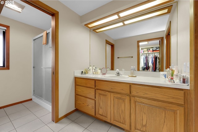 bathroom with tile patterned flooring, a shower with shower door, and vanity