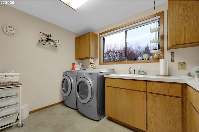 laundry room with cabinets, sink, and washing machine and dryer