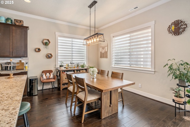 13372 SW Aubergine Ter, Sherwood, OR 97140 - dining space with visible vents, crown molding, an inviting chandelier, baseboards, and dark wood finished floors