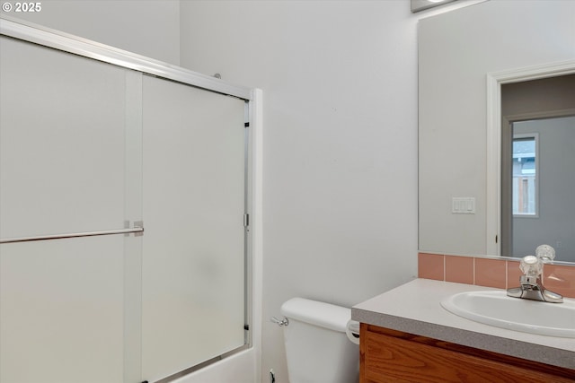 full bathroom featuring vanity, bath / shower combo with glass door, and toilet